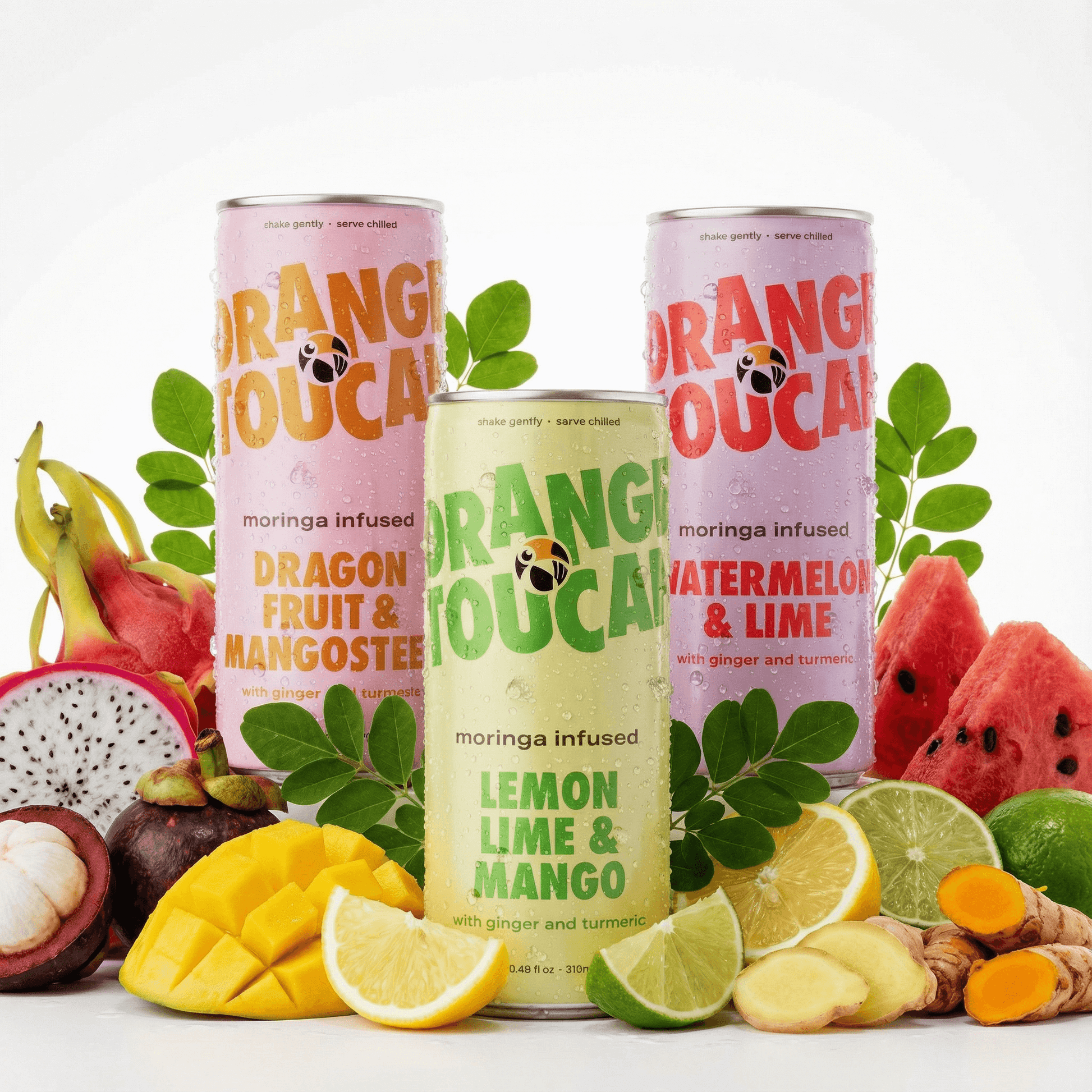 Three cans of Orange Toucan drinks with fruit and leaves on a white background