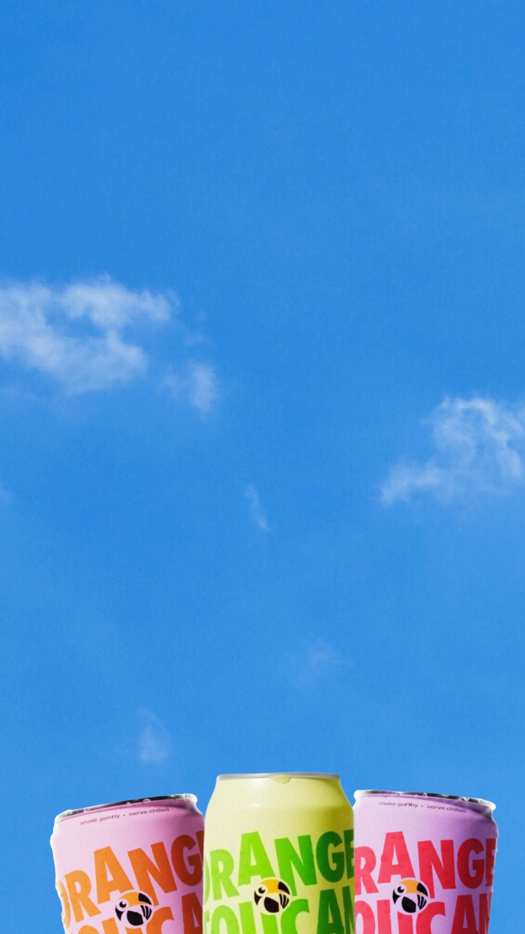 Three cans of Orange Toucan against a blue sky with white clouds