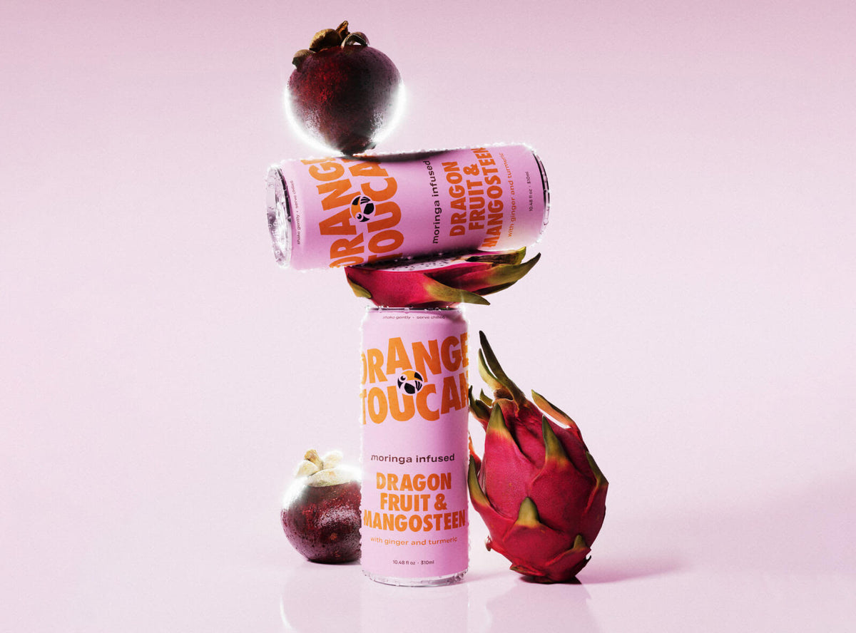 Dragon Fruit & Mangosteen cans stacked with dragon fruit and mangosteen