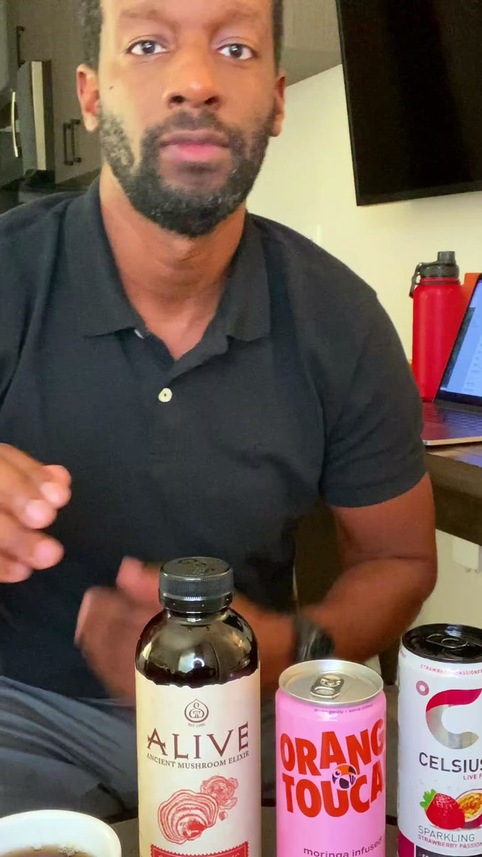 Coach Justin at his desk with a can of Orange Toucan