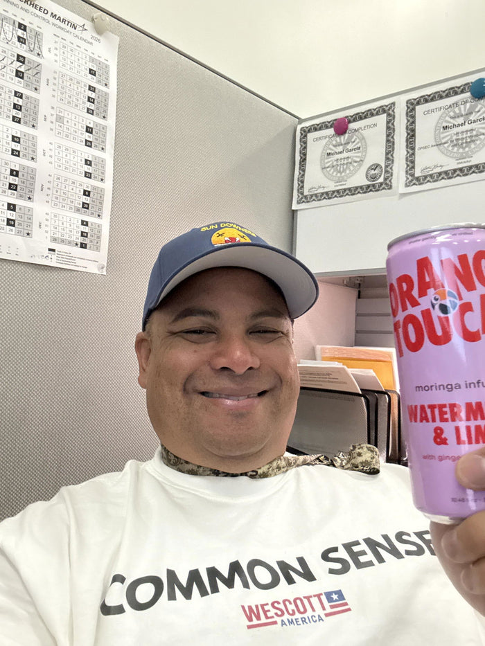 Michael G. at his desk with a can of Orange Toucan